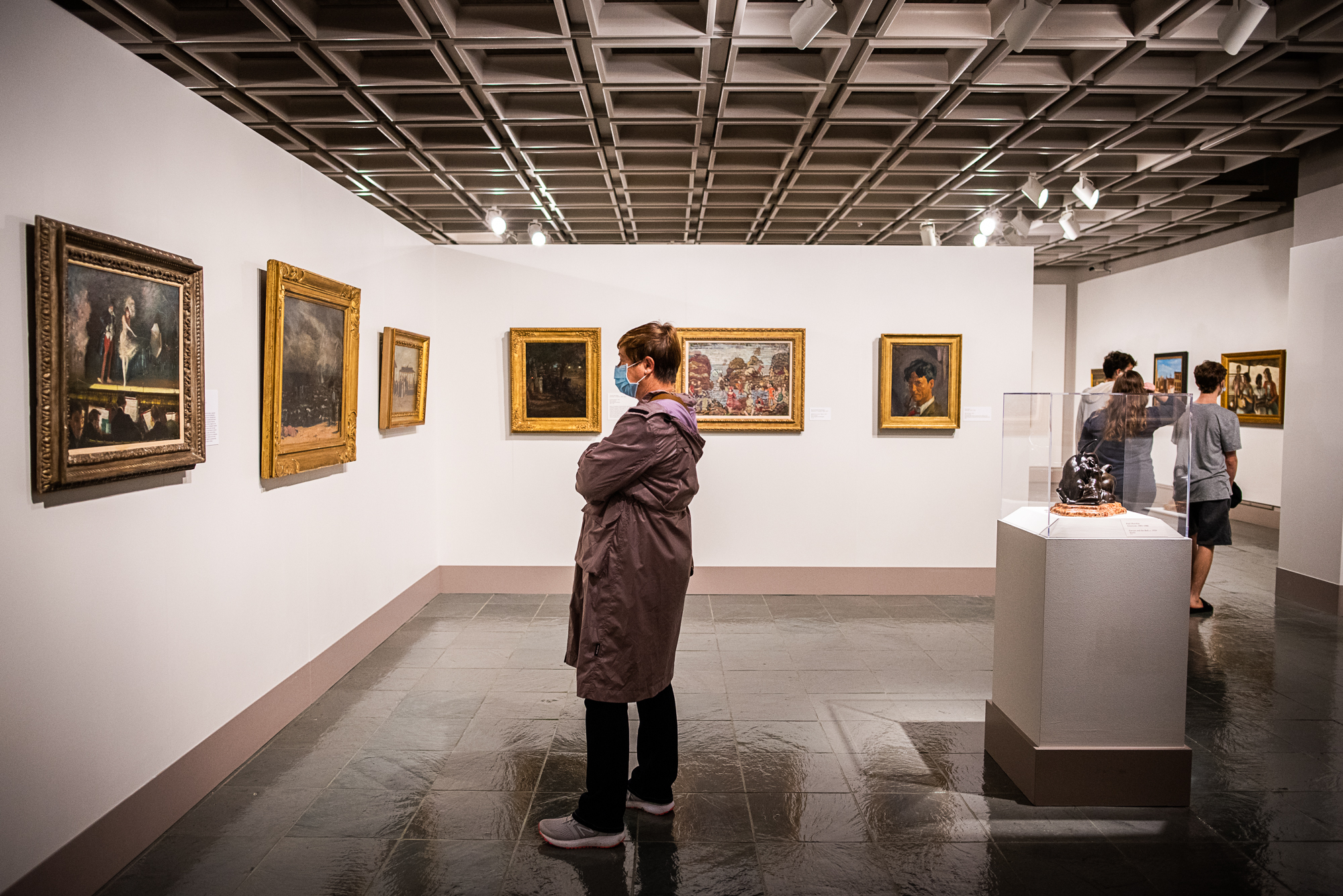 A visitor examining an artwork in the Hull Gallery